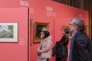Besucherinnen und Besucher vor Kunstwerken in der Ausstellung zu Herzog Georg II.