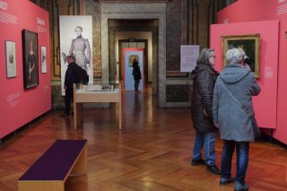 Besucher und Besucherinnen schauen sich die Ausstellung zu Georg II. an.