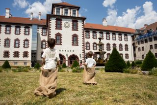 Zwei Kinder beim Sackhüpfen im Schlosshof.