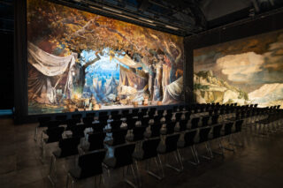 Originales historisches Bühnenbild ‚Lager vor Pilsen‘ mit Zelten und Lagerelementen.