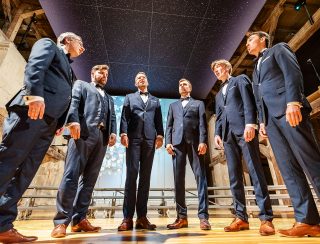 Sechs Männer eines Männerchors stehen im Halbkreis und singen während der Chorschätze in der Peterskirche.